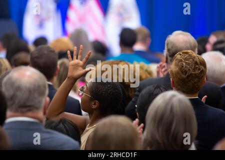 Seattle, Washington, USA. 15 agosto 2023. Un sostenitore fa un gesto di mano di applauso silenzioso in un evento che celebra il primo anniversario della firma della legge sulla riduzione dell'inflazione presso McKinstry, una società di costruzioni di energia verde, nel distretto industriale di Seattle. Credito: Paul Christian Gordon/Alamy Live News Foto Stock