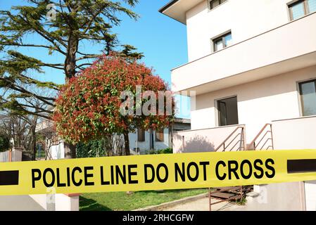 Nastro giallo della scena del crimine che blocca la casa all'aperto Foto Stock