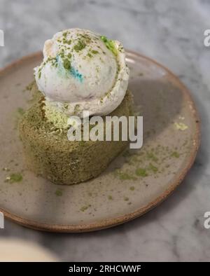 dessert dolce con neve sulla cima, matcha spolverato su tutto il dessert, fondo di marmo Foto Stock