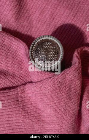 Rasoio anti-pilling. Dispositivo per la rasatura degli abiti. Rasoio in tessuto anti-peluche. Pulitore elettrico portatile pillola defuzzer pelucchi da rosa acrilico o lana maglione. Rasoio elettrico per tessuti dopo la pulizia e la raccolta di lanugine. Maglione da primo piano a pilled. Vecchi vestiti usati con il pilling. Foto Stock