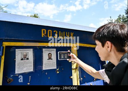 Non esclusiva: ORIKHIV, UCRAINA - 10 AGOSTO 2023 - Una donna scatta una foto delle foto del presidente russo Vladimir Putin e del collaboratore russo Foto Stock