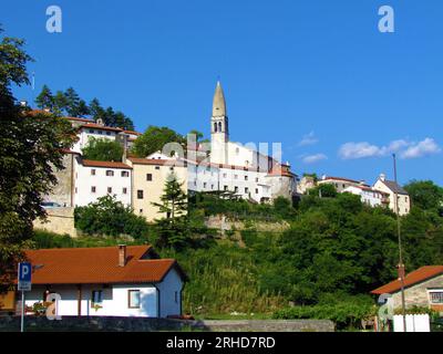 Vista di una piccola città storica di Stanjel, nella regione carsica e litorale della Slovenia, con la chiesa di San Daniel Foto Stock