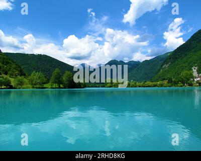 Lago color turchese al Most na Soci nella regione Littoral della Slovenia e montagne delle alpi Giulie alle spalle in estate Foto Stock