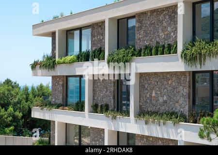 Vicino all'esterno di un moderno edificio residenziale con facciata verde. Architettura moderna e sostenibile Foto Stock