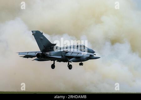 RAF Panavia Tornado GR4 aereo da caccia a reazione atterrando dopo aver preso parte a uno scenario di battaglia dimostrativo di ruolo per gli aeroplani, con il fumo che si riversa dall'attacco al campo di aviazione Foto Stock