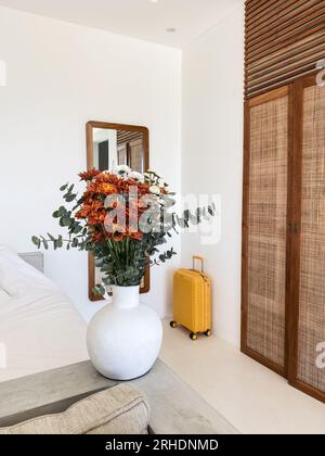 Bouquet di crisantemi arancioni con foglie di eucalipto e valigia gialla all'interno Foto Stock