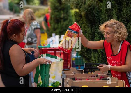 Madrid, Spagna. 16 agosto 2023. Una donna riceve pane donato da Fundacion Madrina. Fundacion Madrina fornisce fan a bambini e madri vulnerabili, per far fronte alle alte temperature e alle onde di calore durante l'estate, oltre a fornire cibo e vestiti. La Fundacion Madrina è un ente di assistenza benefica dedicato all'assistenza e all'aiuto di gruppi a rischio di esclusione o emarginazione nel campo dell'infanzia, delle donne e della maternità. Crediti: Marcos del Mazo/Alamy Live News Foto Stock