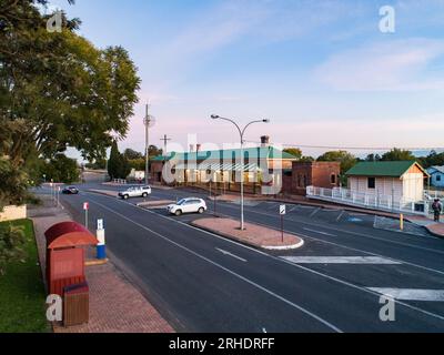 Immagine aerea del terminal dei trasporti pubblici della fermata dell'autobus e della stazione ferroviaria al crepuscolo con la strada in mezzo Foto Stock