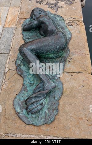 Bronze sculpture 'Sleeping mermaid' ('Sirenetta Dormiente') by Giampaolo Parini on the quay of the Old Dock ('Vecchia Darsena') Savona, Liguria, Italy Stock Photo