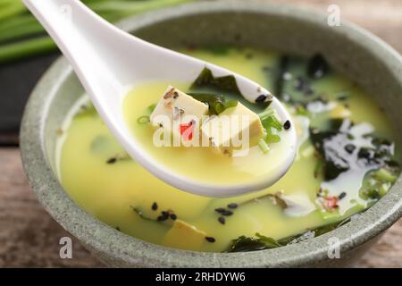 Deliziosa zuppa di miso con tofu nel cucchiaio sopra il recipiente, primo piano Foto Stock