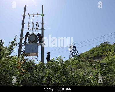 Baoding, contea di Laishui, provincia di Hebei nella Cina settentrionale. 16 agosto 2023. I lavoratori riparano una centrale elettrica nel villaggio di Beilongmen, Jiulong Township, Laishui County, nella provincia di Hebei nella Cina settentrionale, 16 agosto 2023. La contea di Laishui ha subito pesanti piogge a causa dell'impatto del tifone Doksuri di recente. Le autorità locali hanno attivamente effettuato una ricostruzione di emergenza post-catastrofe per garantire che i residenti rimangano al sicuro e aiutare le regioni colpite dalle inondazioni a rimettersi in carreggiata. Crediti: Luo Xuefeng/Xinhua/Alamy Live News Foto Stock