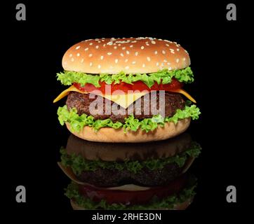 Grande hamburger con grande cotoletta di manzo su sfondo nero con primo piano a riflessione Foto Stock