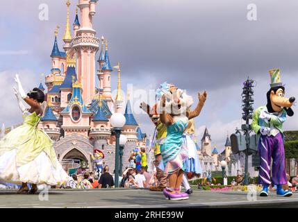 Disneyland Paris; personaggi Disney di fronte al castello di Disneyland che ballano durante la parata di Disneyland; Principessa Tiana, Clarice e Pippo; Francia Foto Stock