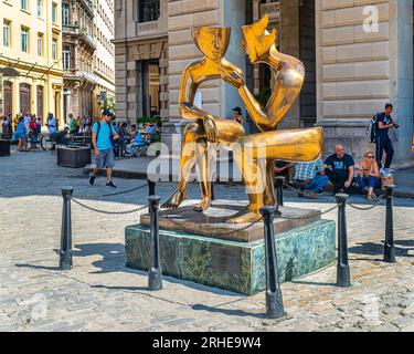 Cuba Havana. Una scultura dorata di due persone in Plaza Vieja, l'Avana Cuba. Turisti sulla strada dell'Avana Vecchia. Ristoranti e caffè. Foto Stock