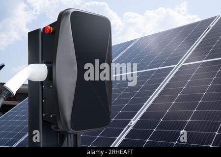 Primo piano della stazione di ricarica per auto elettriche sullo sfondo dei pannelli solari. Foto Stock