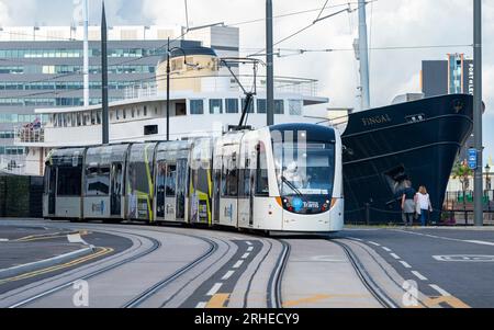 Tram di Edimburgo che corre su Ocean Drive con la nave dell'hotel Fingal a Leith, Edimburgo, Scozia, Regno Unito Foto Stock