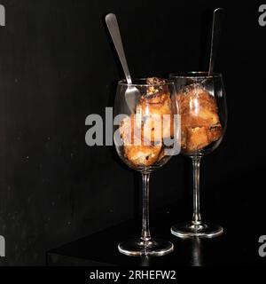 dessert servito in tazze di dulce in padella su sfondo nero con lamponi e fragole, messico america latina Foto Stock