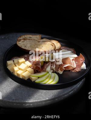 piatto di salumi con formaggio, mela acida, prosciutto serrano con olive, pane tostato, messico america latina Foto Stock