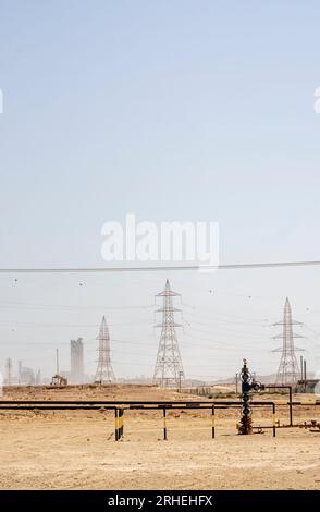 Infrastrutture del giacimento petrolifero del Bahrein - pali elettrici, tubi dell'olio Foto Stock