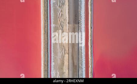 Vista aerea del lago salato rosa. Gli impianti di produzione del sale hanno evaporato lo stagno salamoia in un lago salato. Salin de Giraud saline nella Camargue in Provenza. Foto Stock