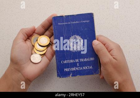 Scheda di lavoro per il Brasile. Traduzione - Repubblica Federativa del Brasile, Ministero del lavoro. Scheda di lavoro per il Brasile con soldi sul lato. simboleggiando l'importanza Foto Stock