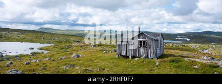 vecchio fienile e rocce sulla pianura di hardangervidda in norvegia Foto Stock