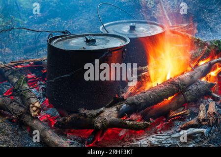 due bollitori fumati da turisti su un camino caldo Foto Stock