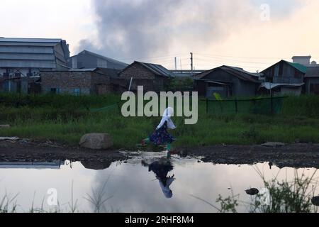 Dhaka, Dhaka, Bangladesh. 16 agosto 2023. A causa del fumo proveniente dai mulini di laminazione dell'acciaio a Shyampur, Dacca, l'ambiente sta diventando inquinato a morte. Questo fumo copre le aree circostanti come una fitta nebbia. A volte la luce del sole non è visibile durante il giorno. Nonostante le lamentele dei residenti locali, questo inquinamento ambientale estremo non può essere fermato. Ci sono più di cento mulini in quest'area. I residenti sono a grave rischio per la salute a causa del fumo nero tossico. (Immagine di credito: © Syed Mahabubul Kader/ZUMA Press Wire) SOLO USO EDITORIALE! Non per USO commerciale! Foto Stock