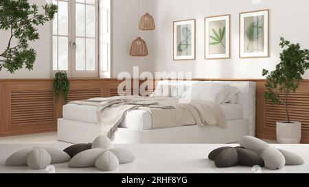 Tavolo bianco, scrivania o ripiano con cinque morbidi cuscini bianchi a forma di stelle o fiori, su una moderna camera da letto con letto e parete in legno, ar bianco Foto Stock