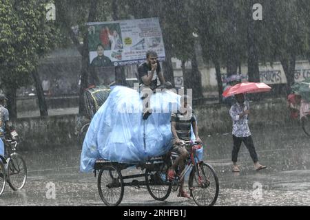 Dhaka, Bangladesh. 16 agosto 2023. Persone che usano la plastica come ombrello durante la passeggiata per strada durante le piogge a Dacca, Bangladesh, il 16 agosto 2023. Foto di Habibur Rahman/ABACAPRESS.COM Credit: Abaca Press/Alamy Live News Foto Stock