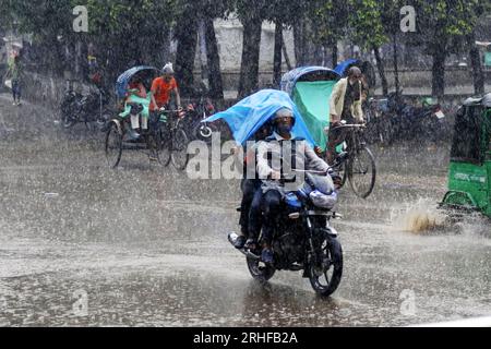 Dhaka, Bangladesh. 16 agosto 2023. Persone che usano la plastica come ombrello durante la passeggiata per strada durante le piogge a Dacca, Bangladesh, il 16 agosto 2023. Foto di Habibur Rahman/ABACAPRESS.COM Credit: Abaca Press/Alamy Live News Foto Stock