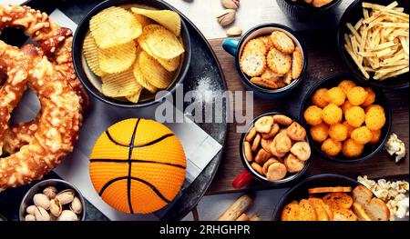 Set di vari tifosi di pallacanestro e spuntini, patatine, salse su sfondo bianco. Bottiglie di birra e accessori per ventole. Vista dall'alto. Foto Stock