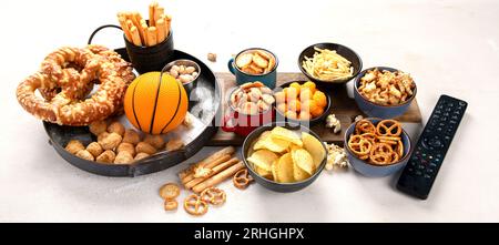 Set di vari tifosi di pallacanestro e spuntini, patatine, salse su sfondo bianco. Bottiglie di birra e accessori per ventole. Vista dall'alto. Panorama. Foto Stock