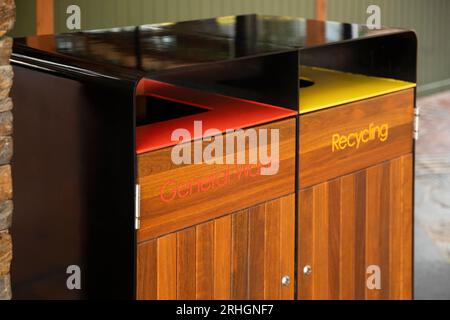 I moderni contenitori per rifiuti e riciclaggio, elegantemente progettati con una finitura in legno, combinano stile e funzionalità. Foto Stock