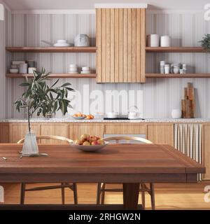 Cucina rustica in legno e sala da pranzo in toni bianchi e beige. Armadi e tavolo con sedia. Tappezzeria e pavimento in parquet. Design degli interni della fattoria Foto Stock