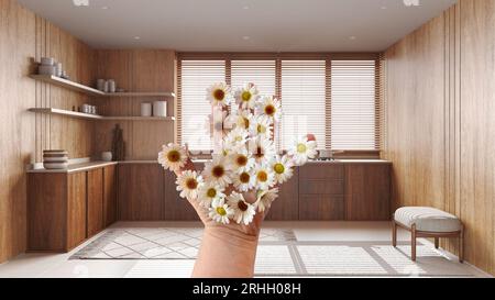 Mano di donna che tiene margherite, primavera e fiori idea, su casa colonica cucina in legno con armadi e mensole, idea di interior design Foto Stock