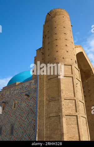 Vista pomeridiana del minareto sinistro dalla facciata anteriore. Nello stile Timirud, luogo simbolo dell'era della via della seta, il mausoleo Khoja Ahmed Yasawi in Turkestan Foto Stock