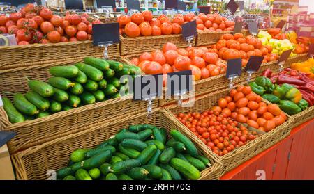 Mercato alimentare di verdure con vuoto prezzo di etichetta etichette. Varie freschi maturi Cetrioli, Pomodori, peperoni e di altri prodotti dell'agricoltura sul marketplace vendita Foto Stock