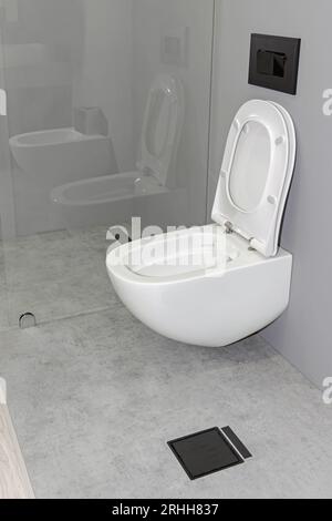 WC in ceramica montato a parete con coperchio aperto e chiusura assistita Foto Stock
