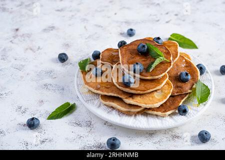 Pancake con miele e mirtilli. Dolci pancake fatti in casa Foto Stock