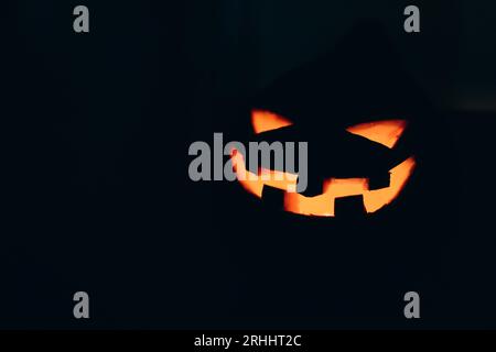 La zucca di Halloween di Jack. Lanterna con candele che brillano al buio. Immagine con messa a fuoco selettiva . Foto Stock