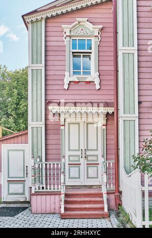 Annesso, portico, finestra con architravi intagliati, facciata rosa del lungomare - dettagli in legno a due piani di casa residenziale tartara ricostruita all'inizio del XX secolo Foto Stock