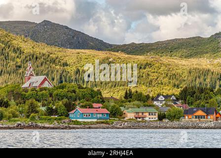 Chiesa di Buksnes e villaggio di Gravdal alle Isole Lofoten, Norvegia visto dal mare Foto Stock