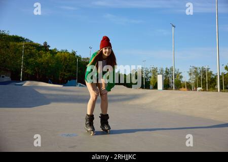 Una teenager che pattina in linea sul lungomare facendo acrobazie e trucchi Foto Stock