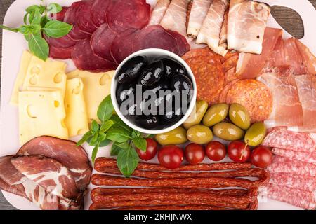 Cornice completa di vari antipasti di olive, tagli di salsicce e formaggi. Background alimentare. Foto Stock