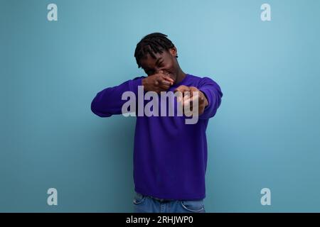 un giovane americano di colore positivo con dei dreadlocks che sorridono e scherzano Foto Stock