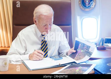 Milwaukee, Stati Uniti d'America. 15 agosto 2023. Il presidente degli Stati Uniti Joe Biden esamina i documenti sugli incendi di Maui durante una telefonata con il governatore delle Hawaii Josh Green e l'amministratore della FEMA Deanne Criswell mentre viaggiano a Milwaukee a bordo dell'Air Force One, 15 agosto 2023. Credito: Adam Schultz/White House Photo/Alamy Live News Foto Stock