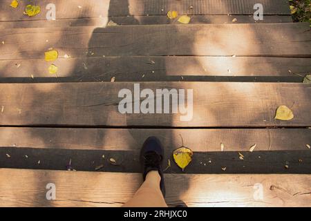 La ragazza scende i gradini di legno del parco, i piedi sui gradini, gli sport e le attività ricreative in Ucraina Foto Stock
