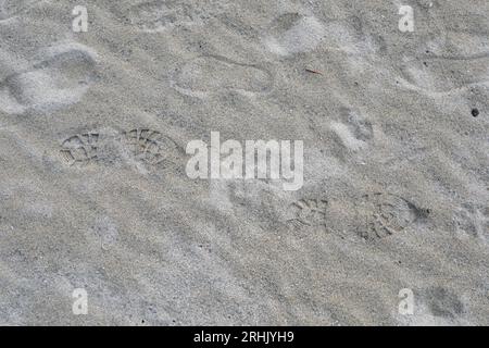Scarponi stampati sulla sabbia sulla spiaggia Foto Stock