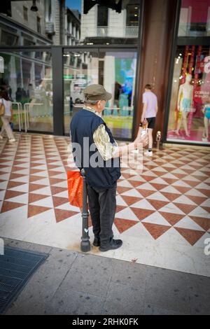 un vecchio in piedi per strada che tiene un gelato in mano Foto Stock